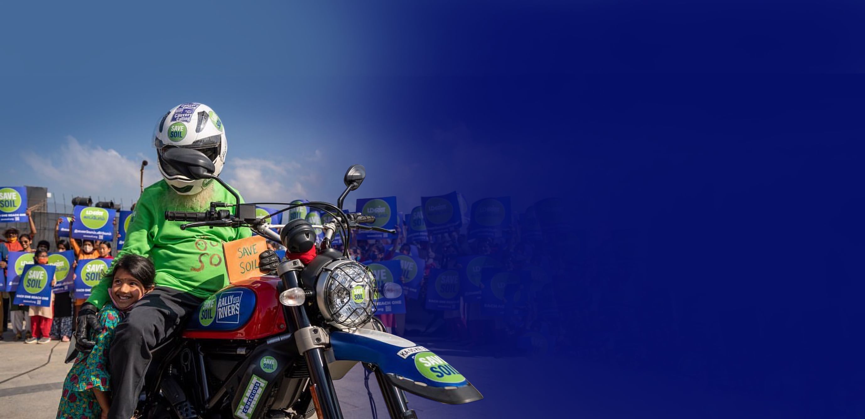 Садхгуру на мотоцикле с логотипом «Спасём Почву», рядом с ребёнком